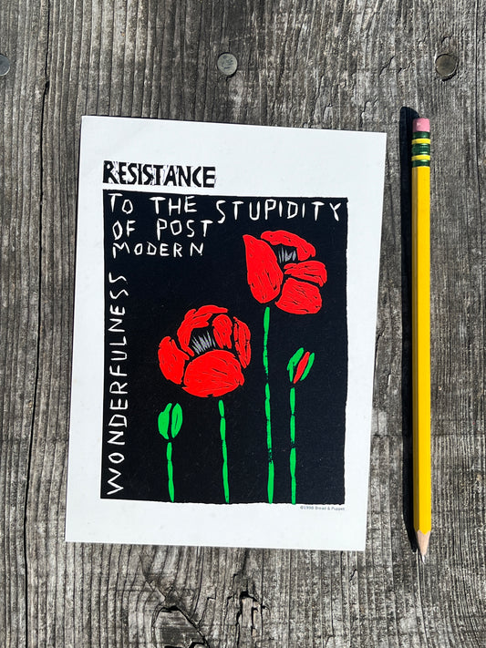 Postcard with red flowers and text on a wooden surface with a pencil.