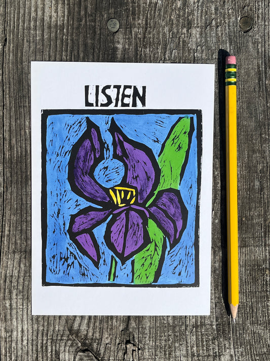 Colorful drawing of a flower with 'LISTEN' on a postcard placed on a wooden surface with a pencil.