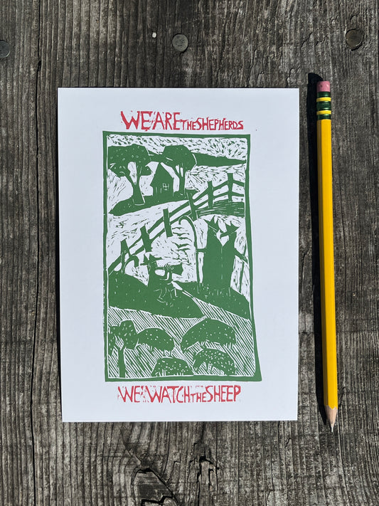 White card with green and red design on a wooden surface with a pencil.